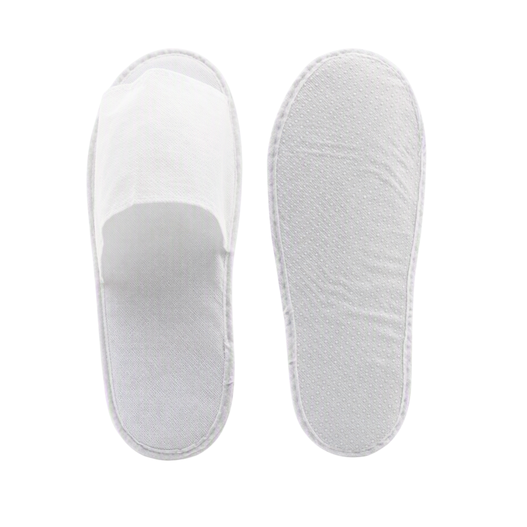 A pair of white disposable slip-on slippers shown from the top, with one slipper displaying the fabric upper and the other showing the textured foam footbed, on a solid white background.