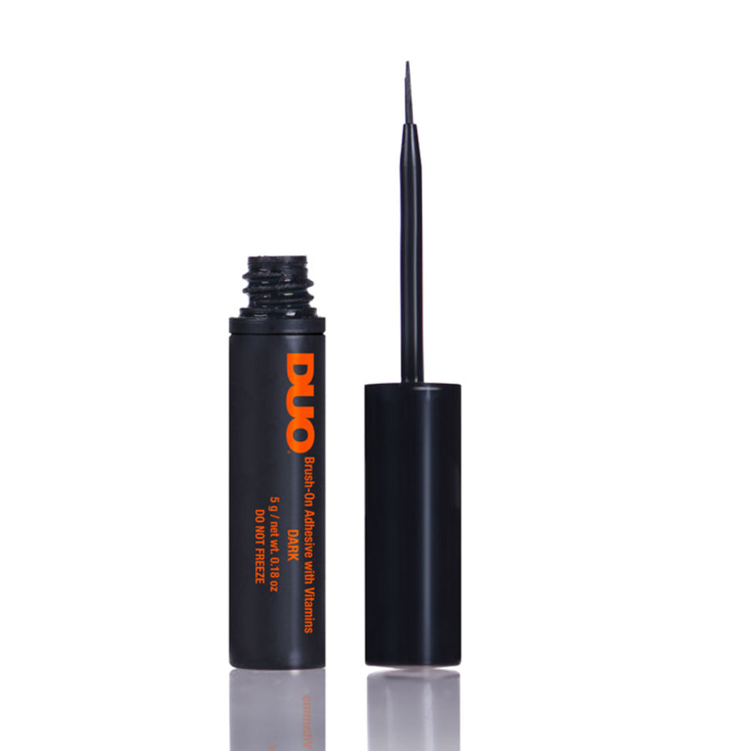 Duo Dark Strip Lash Adhesive in a black bottle with a black cap and fine application brush on a white background, with orange Duo branding