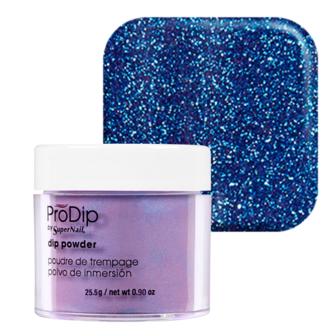 A jar of ProDip SuperNail acrylic dipping powder in front of a square color swatch showing the glitter finish. The product is a light lavender-purple color with a white lid, and the swatch behind it shows a sparkling blue glitter effect.