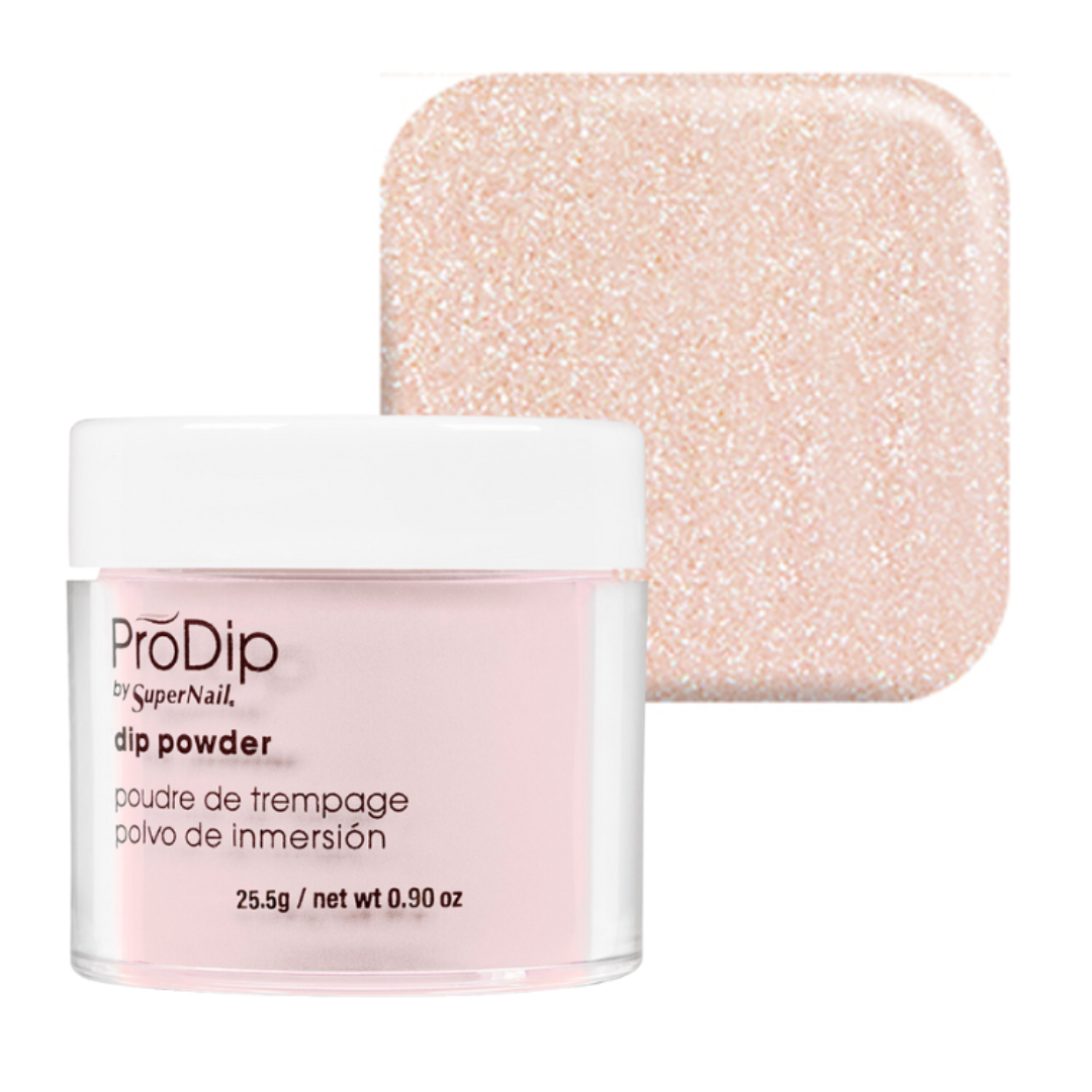 ProDip by SuperNail acrylic dipping powder jar in a pale pink shade with a white lid, shown in front of a square swatch of the same sparkling light pink powder on a white background.