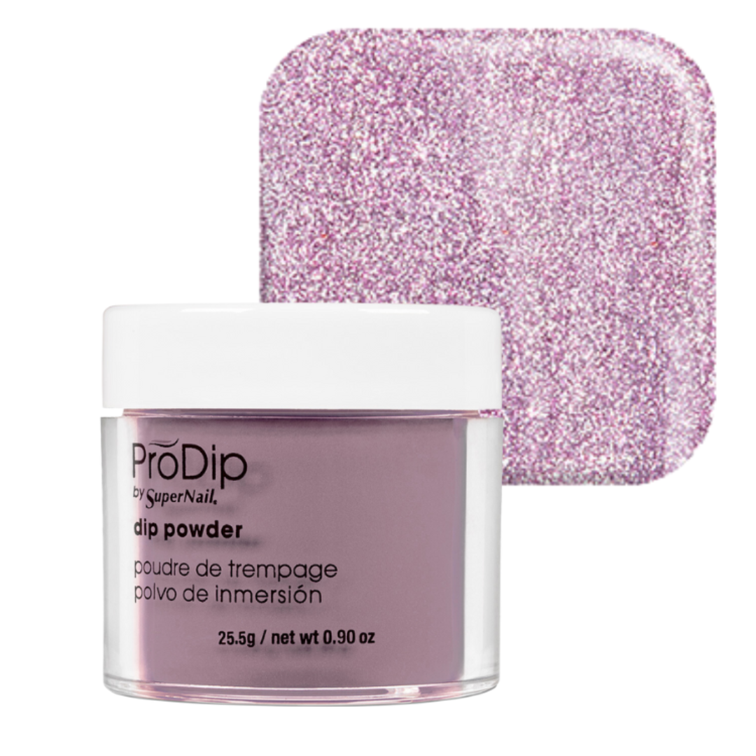 A jar of ProDip by SuperNail acrylic dipping powder in a light lavender-purple shade, shown in front of a square swatch of the same glittery purple powder on a white background.