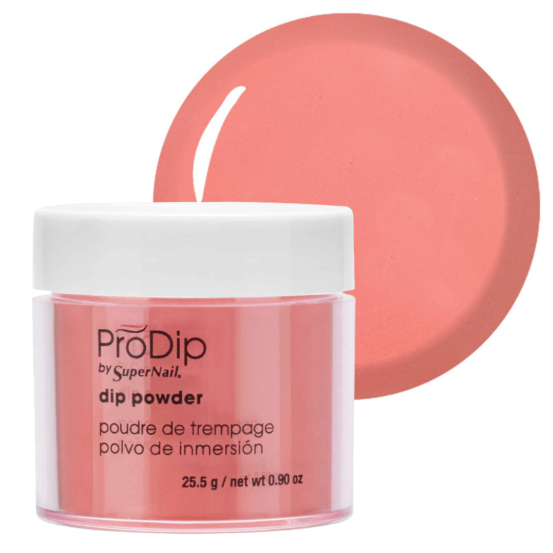 ProDip by SuperNail dip powder in a coral pink shade, shown in a clear jar with a white lid and a matching circular color swatch behind it on a white background.
