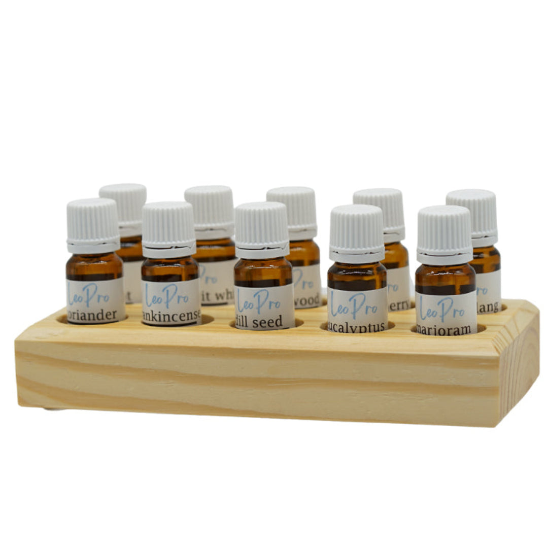A wooden stand with multiple essential oil bottles arranged in it, each labeled with different essential oils such as Frankincense, Rosemary, and Lavender.