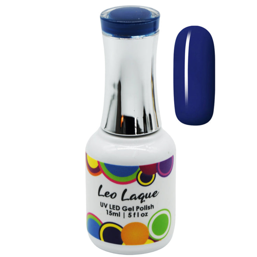 A bottle of Leo Laque UV LED gel nail polish with a metallic silver neck and a white label decorated with colorful circles, shown next to a vertical swatch of the deep navy blue polish.