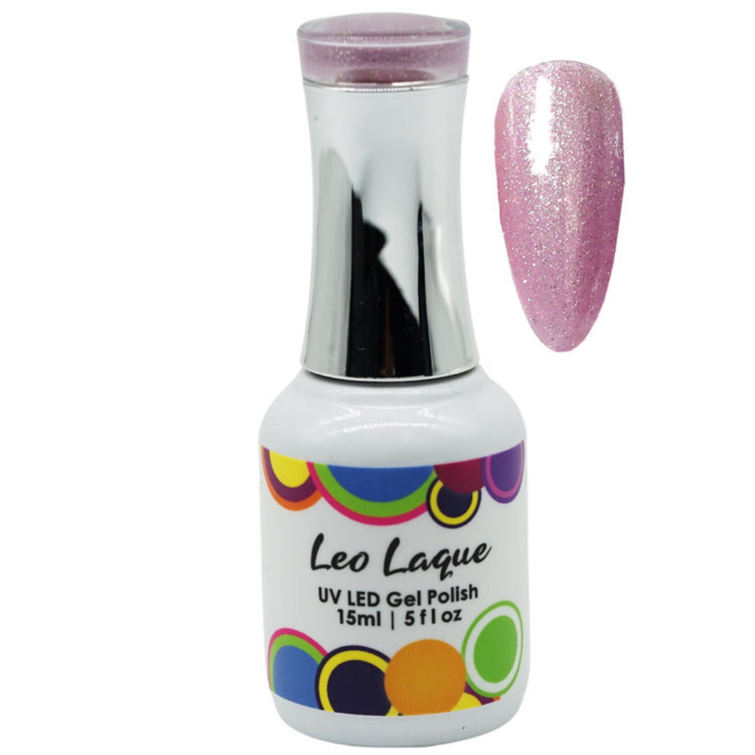 A bottle of Leo Laque UV LED gel polish with a silver cap and a multicolor circular pattern on the label, shown next to a swatch of the pink glitter nail polish.