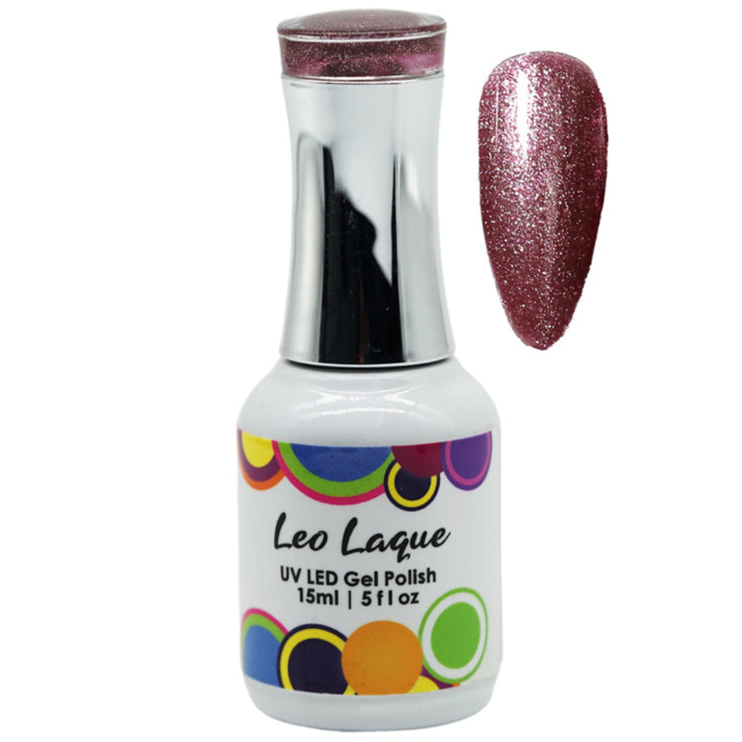 A bottle of Leo Laque UV LED gel nail polish with a silver cap and a white label decorated with colorful circles, shown next to a glittery mauve-pink nail swatch on a white background.