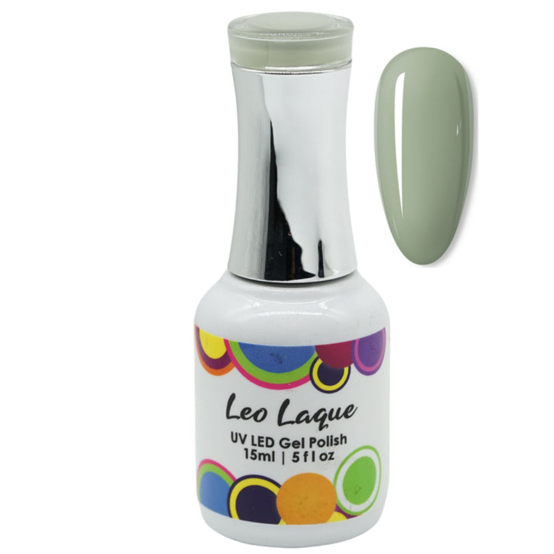 A bottle of Leo Laque UV LED gel polish with a silver cap and a multicolor circular label, shown next to a glossy nail swatch displaying the sage green polish color.