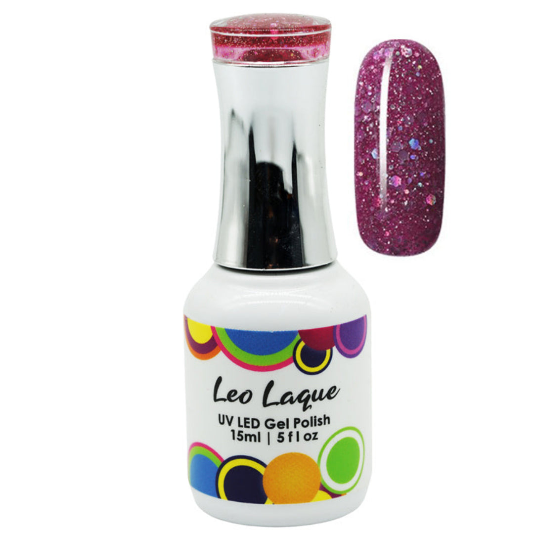 A bottle of Leo Laque UV LED gel nail polish with a silver cap and a white label featuring colorful circles, shown next to a nail swatch displaying a sparkling magenta-purple glitter finish.