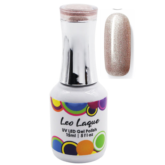 A bottle of Leo Laque UV LED gel polish with a silver cap and a white label featuring colorful circles, shown next to a nail swatch displaying the glittery champagne-gold polish color.
