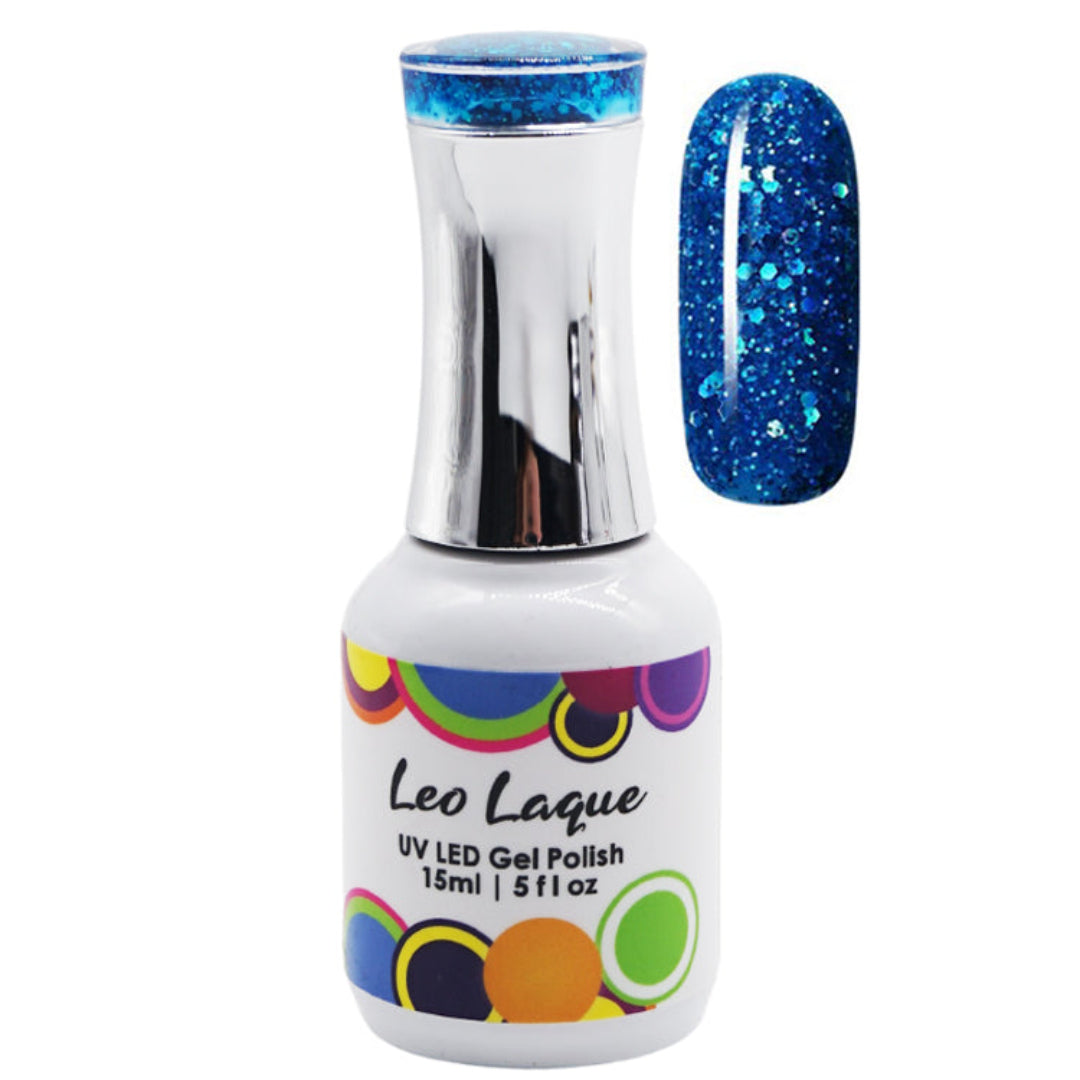 A bottle of Leo Laque UV LED gel nail polish with a silver cap and a white label, shown next to a nail swatch displaying a sparkling blue glitter finish.